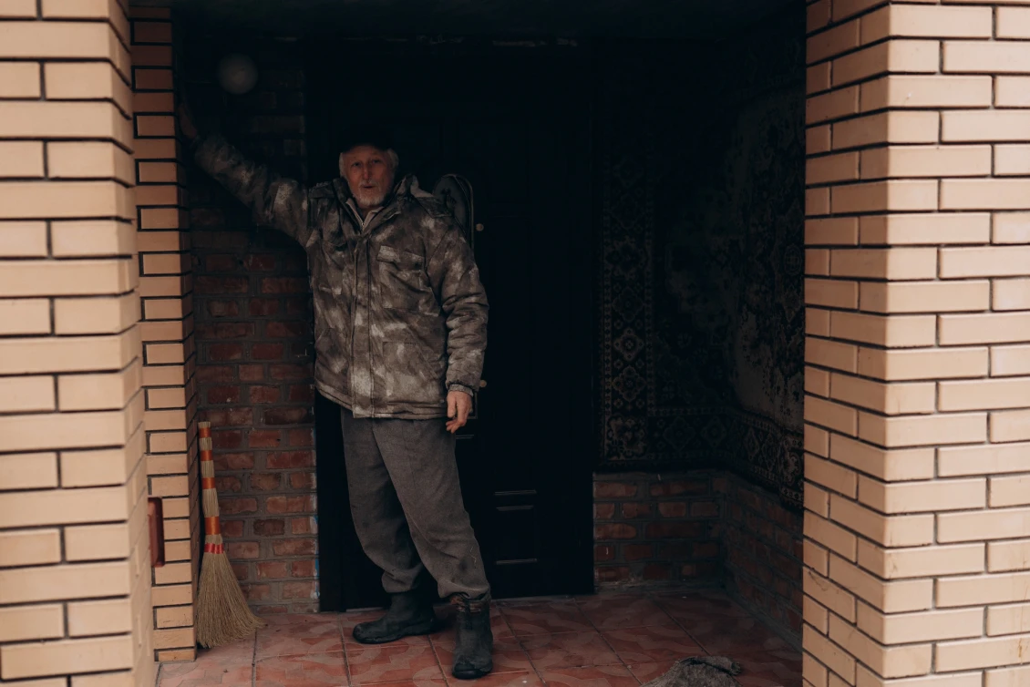 Vasyl shows us the door he installed with our financial aid. The original doors were destroyed by the Russians when they tried to break into his house. 