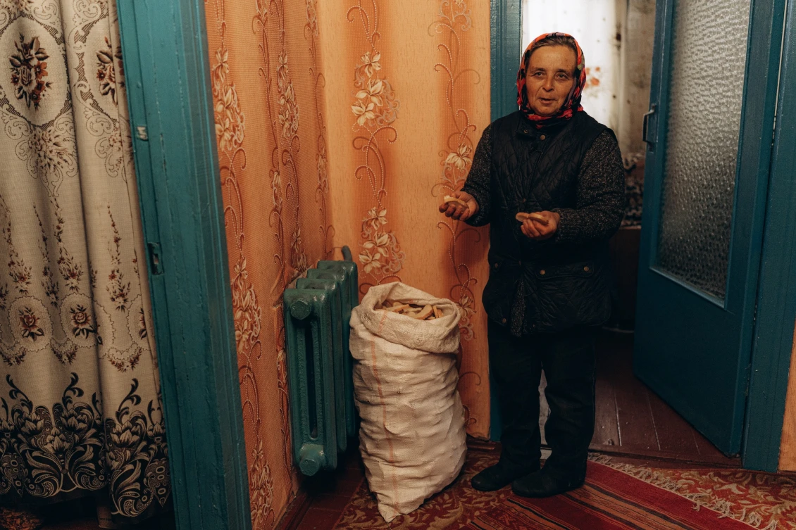 Liubov takes a bag of crackers from the pantry, which she dried in case the Russians invaded again. Like other residents, she and her husband ate canned food and leftovers for more than a month. There was no bread in the village during the occupation.  