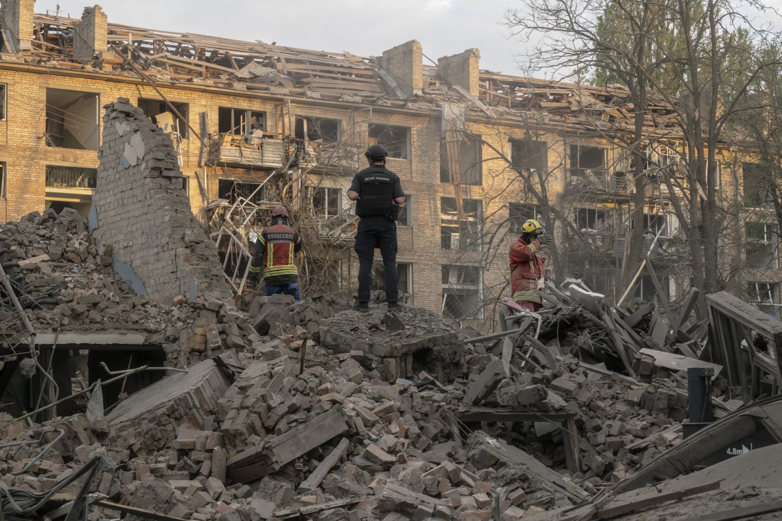 Police officers and members of the State Emergency Service at a site where missiles struck a residential area in Kyiv. Twelve people were killed and about 90 more were wounded in the capital during an overnight missile attack. 