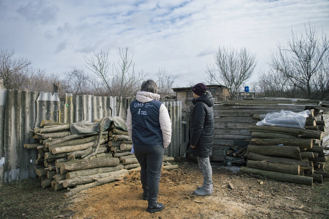 Тетяна показує дрова, які вона купила завдяки фінансовій допомозі
