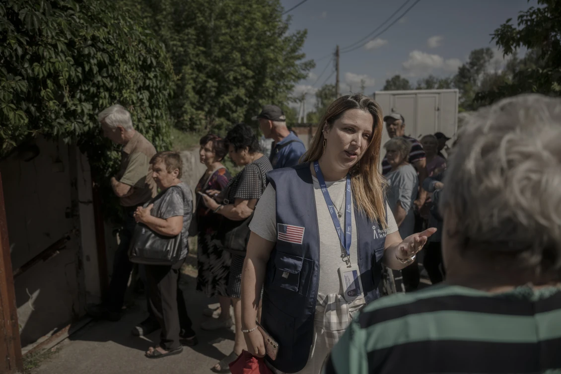 Анастасія спілкується із людьми, яких реєструють на отримання допомоги